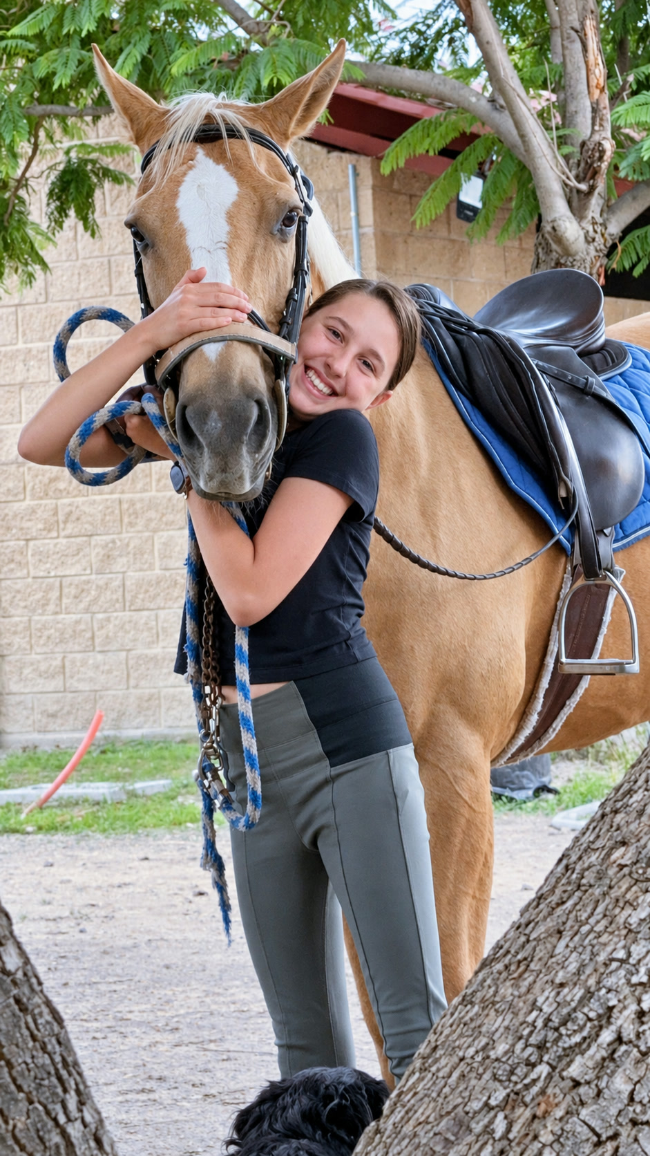 Una alumna abraza a su caballo junto a la pista